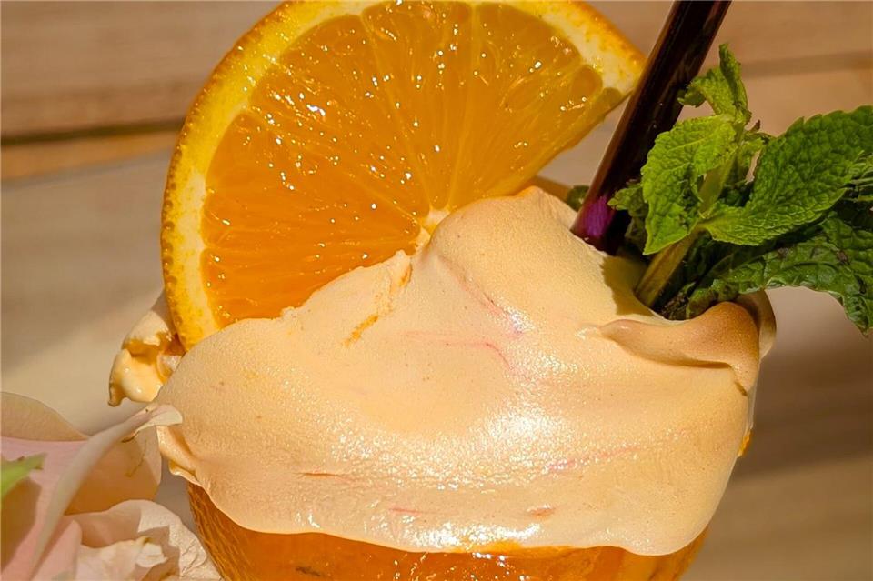 Das Aperol-Eis in der Orangenschale mit flambiertem Baiser sorgt noch für einen zusätzlichen Wow-Effekt. Volker Elm/dpa-tmn