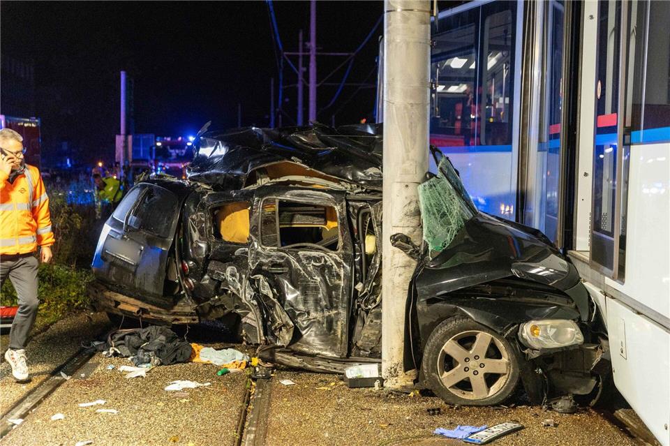 Das Auto wurde zwischen Betonmast und Straßenbahn eingeklemmt, die Aufräumarbeiten dauerten auch nachts noch an.Justin Brosch/dpa