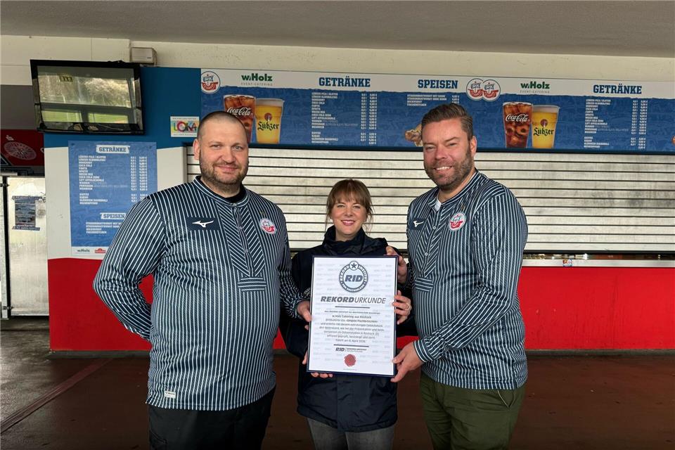 Das Catering-Team des Ostseestadions Rostock um Geschäftsführer Christoph Wulff (r) und Küchenchef Jens Schaumburg (l) hat das längste Fischbrötchen der Welt produziert. Bestätigt wurde der Rekord von Laura Koblischek (M) vom Rekord-Institut Deutschland. (Foto Handout)--/F.C. Hansa Rostock /dpa