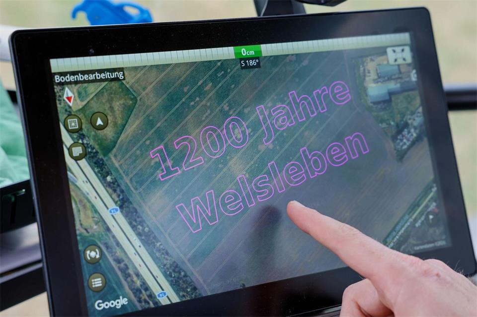 Das Display zeigt die Vorlage von Landwirt Fischer, der mit seinem Traktor den Schriftzug „1200 Jahre Welsleben“ in den Acker grubberte.Peter Gercke/dpa