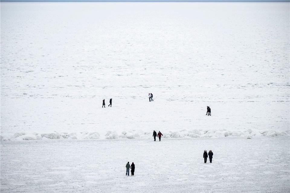 Das Eis auf der Ostsee vor Rügen lockt die Menschen - wie hier bei Sellin.Philip Dulian/dpa