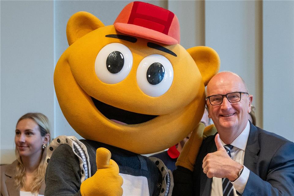 Das Filmpark-Maskottchen „Flimmy“ bringt Brandenburgs Ministerpräsidenten Dietmar Woidke beim Kindertagsfest in der Staatskanzlei zum Lachen. Soeren Stache/dpa
