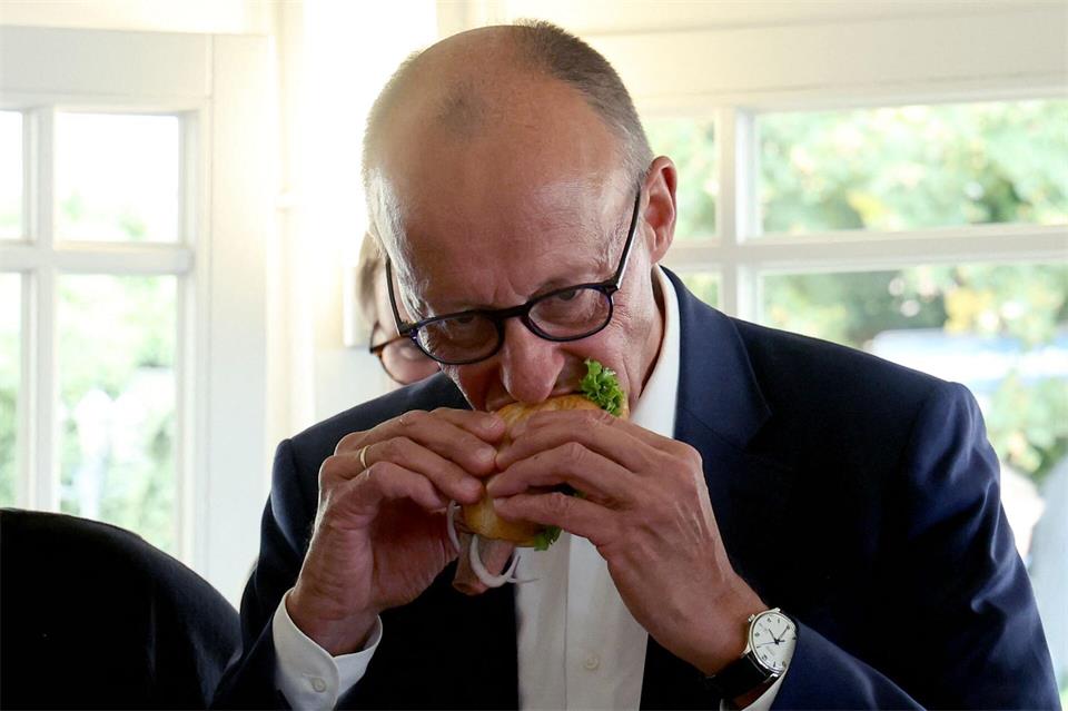 Das Fischbrötchen ließ sich der Kanzler schmecken.Bernd Wüstneck/dpa