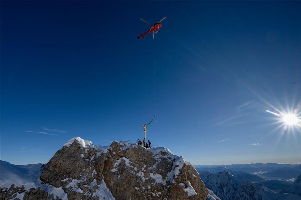 Das Kreuz schwebt am Gipfel ein. Peter Kneffel/dpa