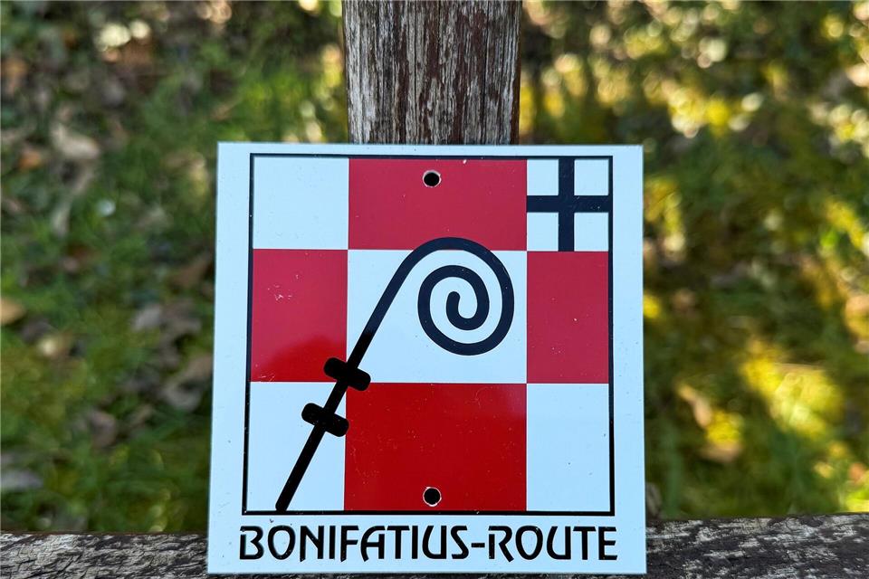 Das Logo der Pilgerroute zeigt einen symbolisierten Bischofsstab auf weiß-roten Karos.Michael Bauer/dpa