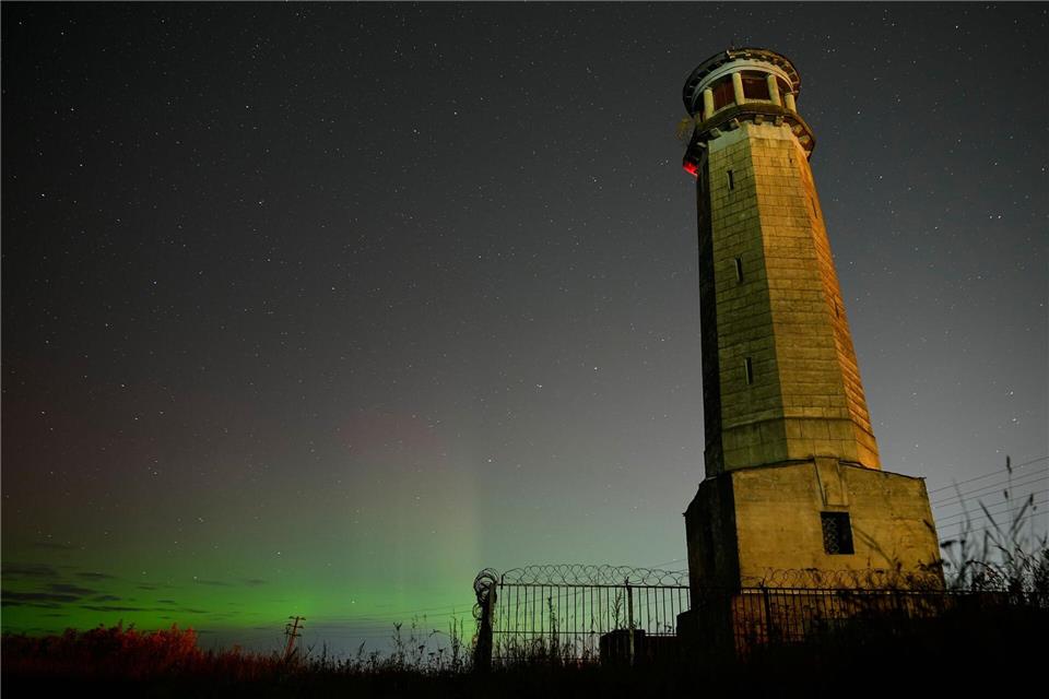 Das Nordlicht, auch bekannt als Aurora Borealis, ist am Nachthimmel in der Nähe des Großen Wolga-Leuchtturms am Ufer des Moskauer Kanals zu sehen.Pavel Bednyakov/AP/dpa