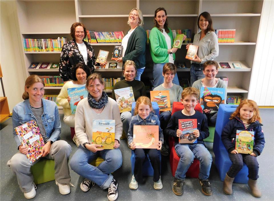 Das Team der Schulbücherei mit der Schulleiterin Maren Kamps (2. Reihe, 1. von links) und einigen jungen Lesern.
