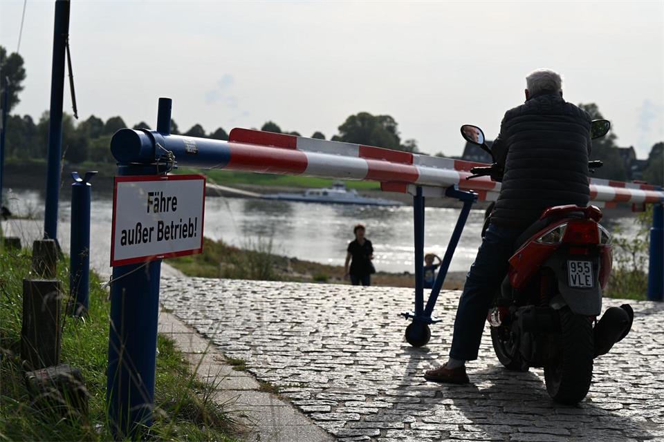 Das Warten auf die Fähre ist vergeblich: Ein Motorroller-Fahrer blickt einige Minuten auf den Rhein, dann kehrt er um und fährt davon. (Archivbild)Wolf von Dewitz/dpa