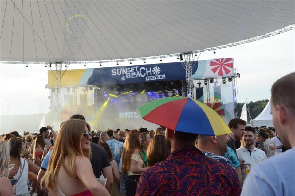 Das große Sonnensegel vor der Bühne spendet zwar Schatten, aber eine eigene Kopfbedeckung schadet bei dem sonnigen Wetter auch nicht.
