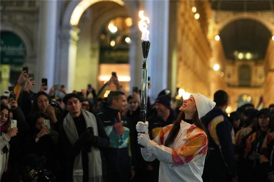 Das olympische Feuer ist bereits in Mailand, Balletttänzerin Nicoletta Manni trägt hier die Fackel.Francisco Seco/AP/dpa