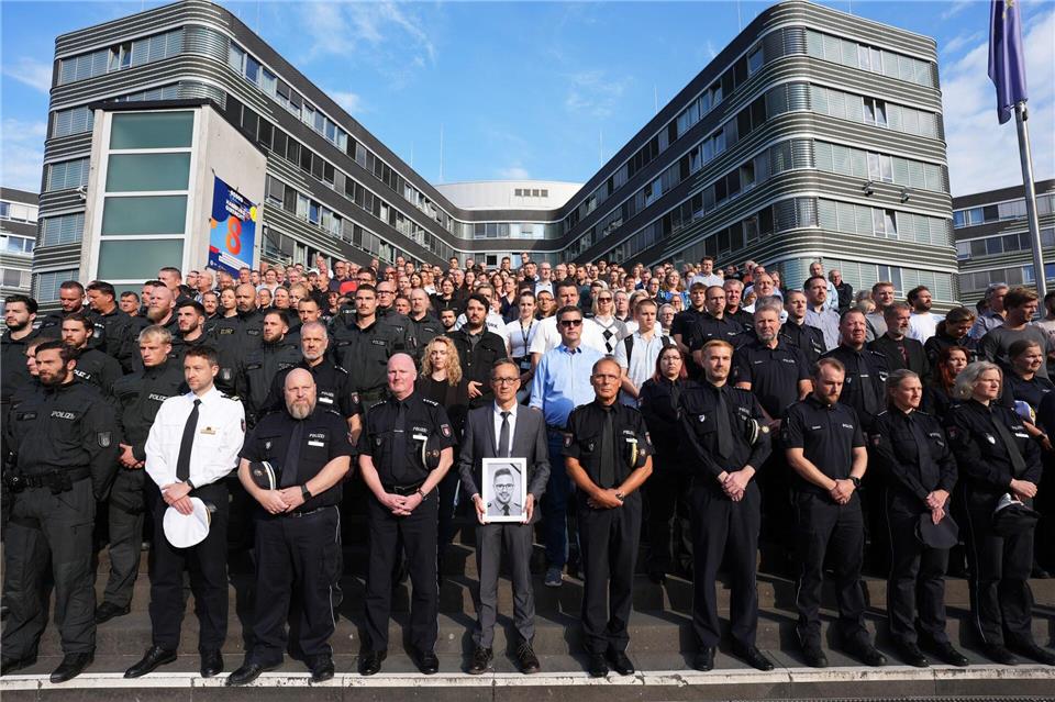 Das saarländische Innenministerium hatte die Polizeibehörden der anderen Länder und des Bundes eingeladen, sich der Gedenkminute anzuschließen. Hier zahlreiche Beamte vor dem Polizeipräsidium in Hamburg.Marcus Brandt/dpa