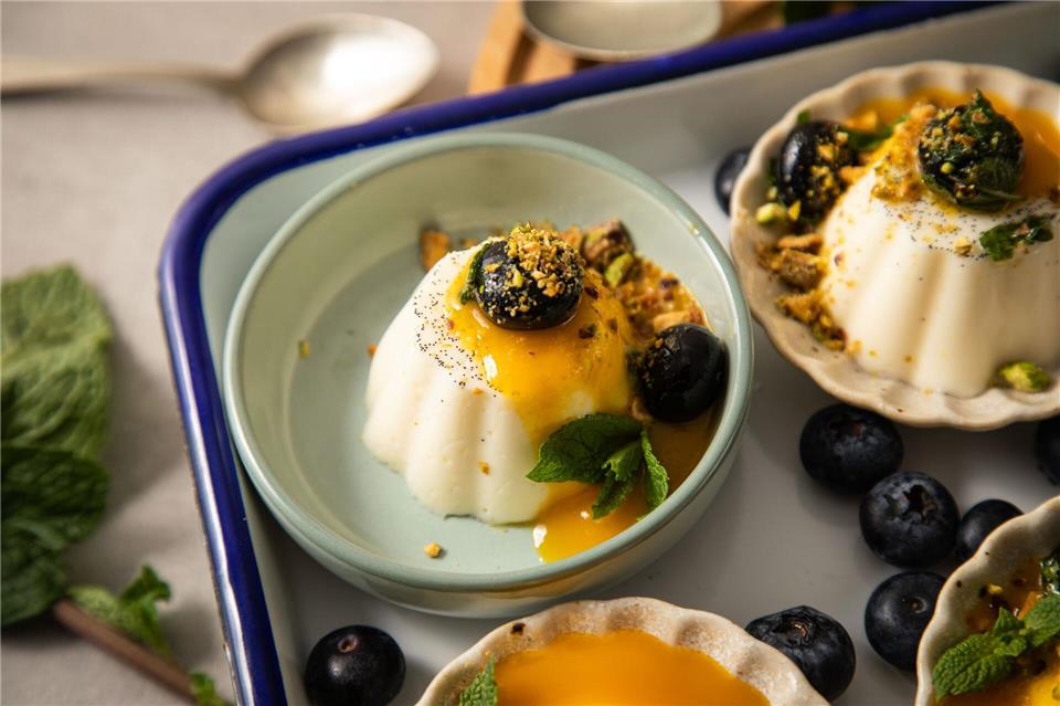 Deko-Vorschlag für die Vanille-Panna Cotta: mit Mangosoße, Blaubeeren, Minze und Pistazien verzieren.Christin Klose/dpa-tmn