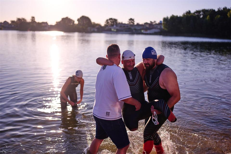 Dem ukrainischen Kriegsveteranen Oleksii Kozak wird bei einer Sportveranstaltung am Rande von Kiew geholfen, aus dem Wasser zu steigen.Francisco Seco/AP/dpa