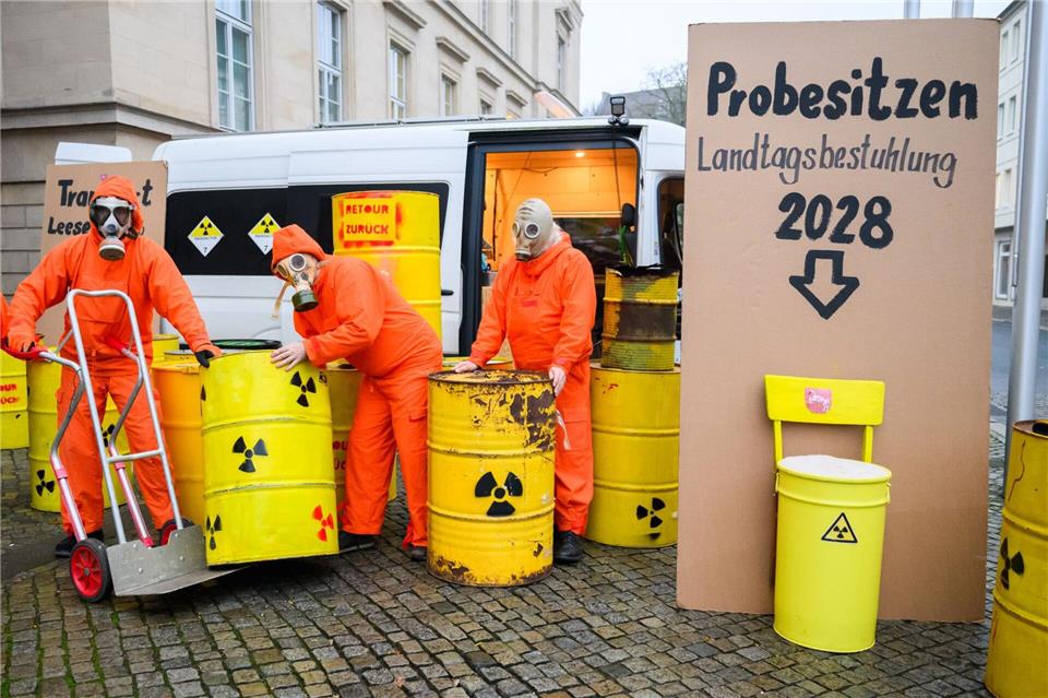 Demonstranten der Bürgerinitiative Strahlenschutz Leese stehen mit künstlichen Atommüllfässern vor dem niedersächsischen Landtag.Julian Stratenschulte/dpa