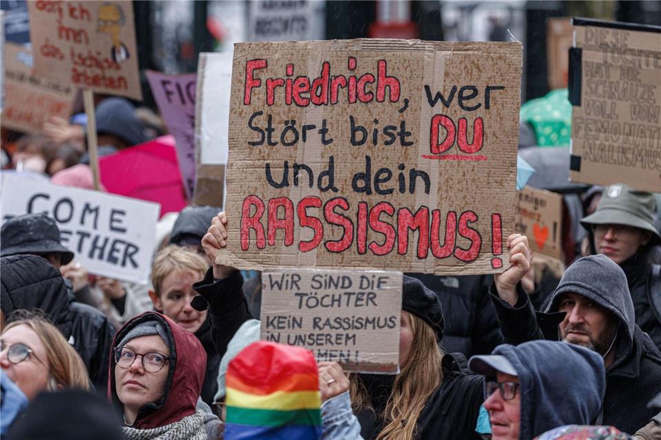 2.600 Menschen protestieren in Hamburg gegen Merz-Äußerung  Demonstranten halten im Regen Schilder mit Parolen gegen Bundeskanzler Friedrich Merz hoch.Markus Scholz/dpa