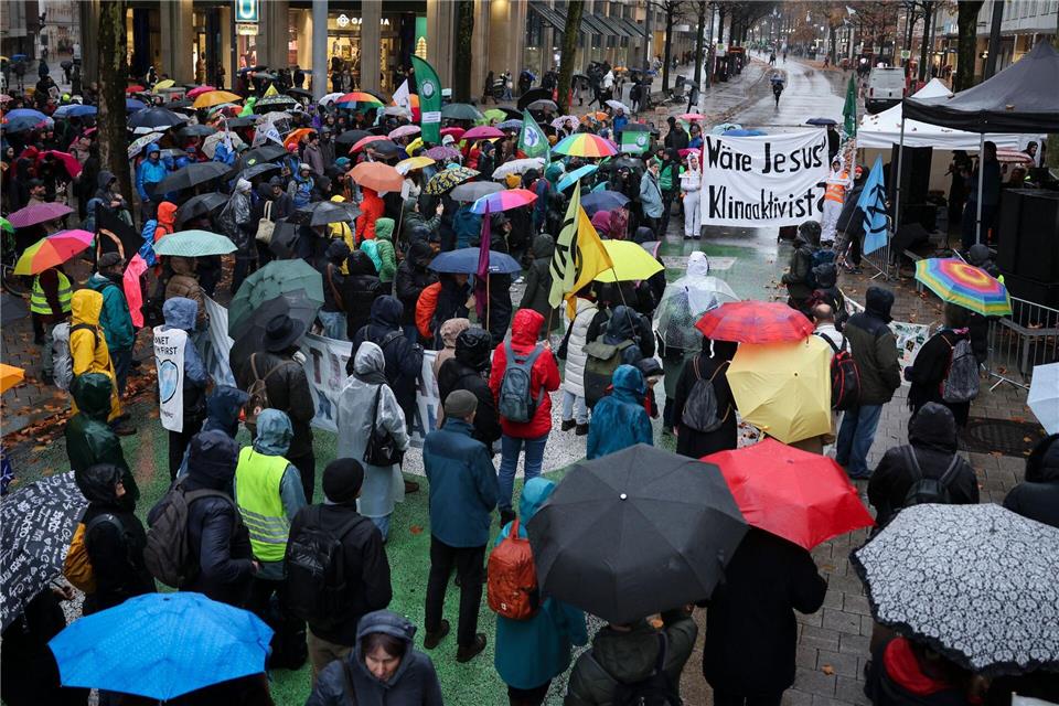 Demonstranten laufen in Hamburg durch den Regen. Christian Charisius/dpa