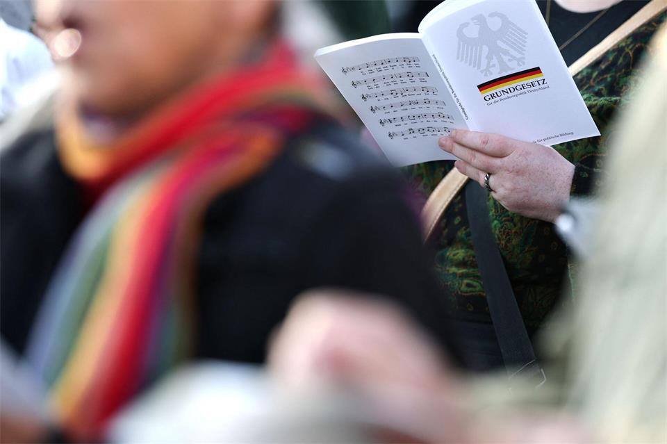 Demonstranten lesen vor dem Magdeburger Landtag laut aus dem Grundgesetz vor. Jan Woitas/dpa