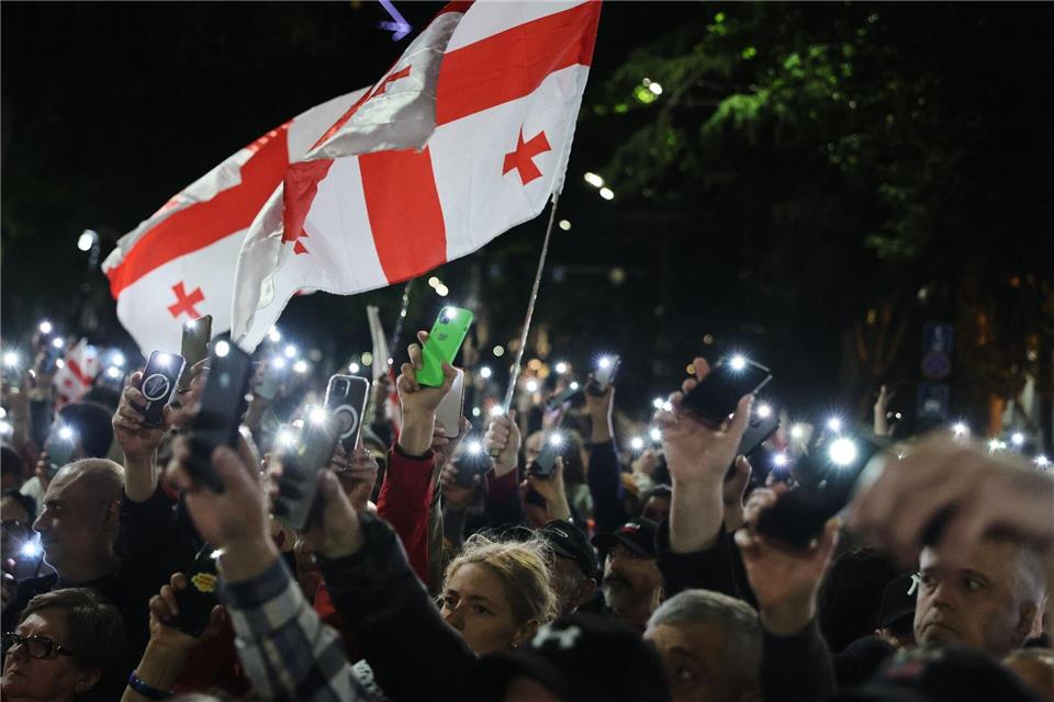 Demonstranten mit einer georgischen Nationalfahne nehmen an einer Kundgebung der Opposition anlässlich des Unabhängigkeitstages in Tiflis teil.Zurab Tsertsvadze/AP/dpa
