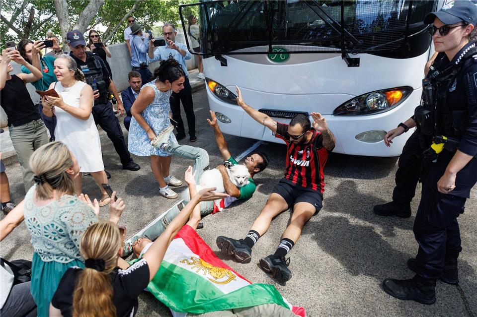 Demonstranten protestierten, während der Bus mit iranischen Spielerinnen und Mitarbeitern abfuhr.Russell Freeman/AAP/dpa