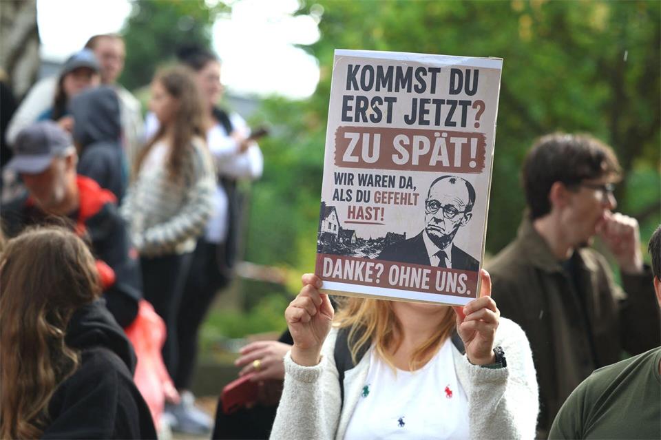 Demonstranten warfen Merz vor, erst nach Ende der Löscharbeiten den Brandort aufzusuchen. Christoph Reichwein/dpa