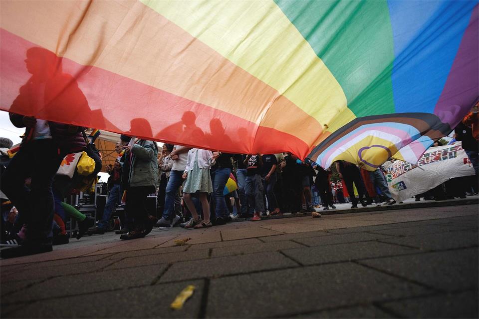Demonstranten ziehen mit einer riesigen Regenbogenfahne als Zeichen für Vielfalt und Toleranz beim CSD in Hennigsdorf durch die Straßen.Carsten Koall/dpa
