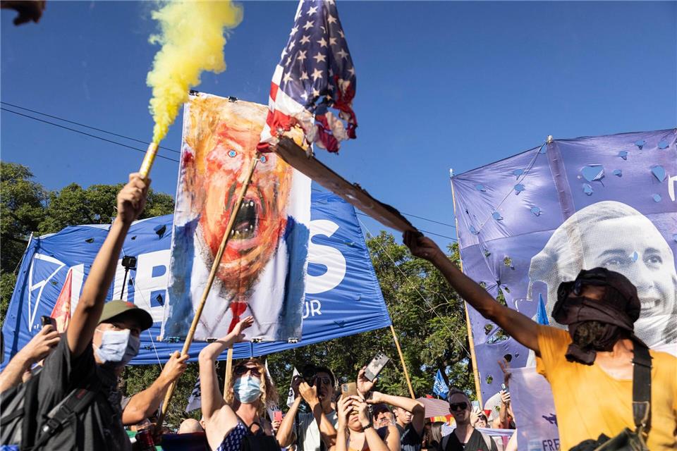 Demonstranten zünden mit einer Fackel eine amerikanische Fahne an.Virginia Chaile/ZUMA Press Wire/dpa