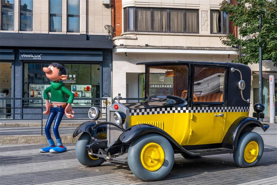 Denkmal für die Comic-Figur Gaston Lagaffe mit seinem gelben Oldtimer von Zeichner André Franquin im Stadtzentrum von Charleroi.Oliver Gerhard/dpa-tmn