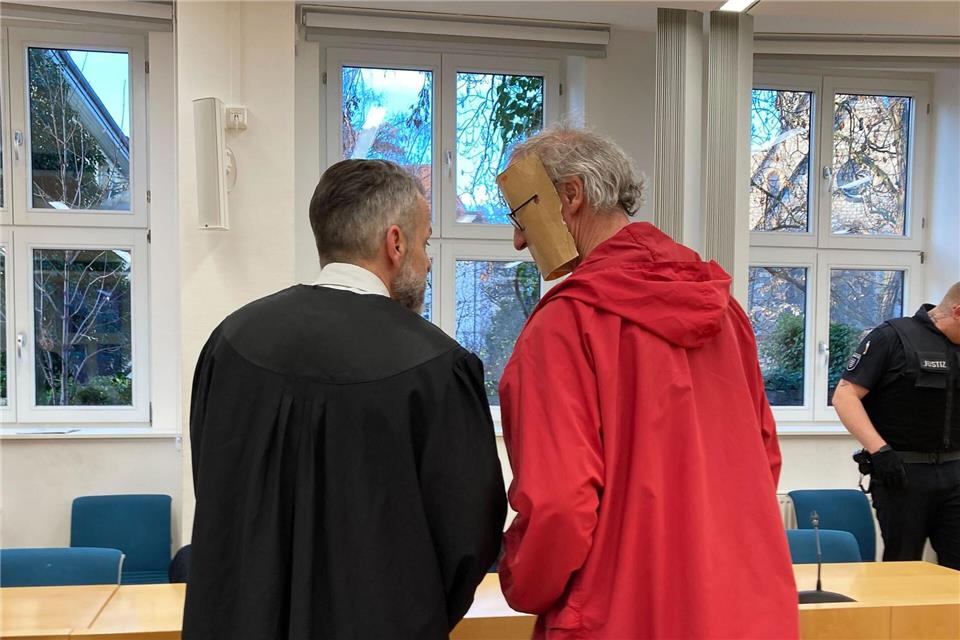 Der 53-jährige Angeklagte trug beim Betreten des Gerichtssaals eine augenscheinlich selbst gebastelte Papp-Maske, die sein Gesicht verdeckte.Marie Frech/dpa