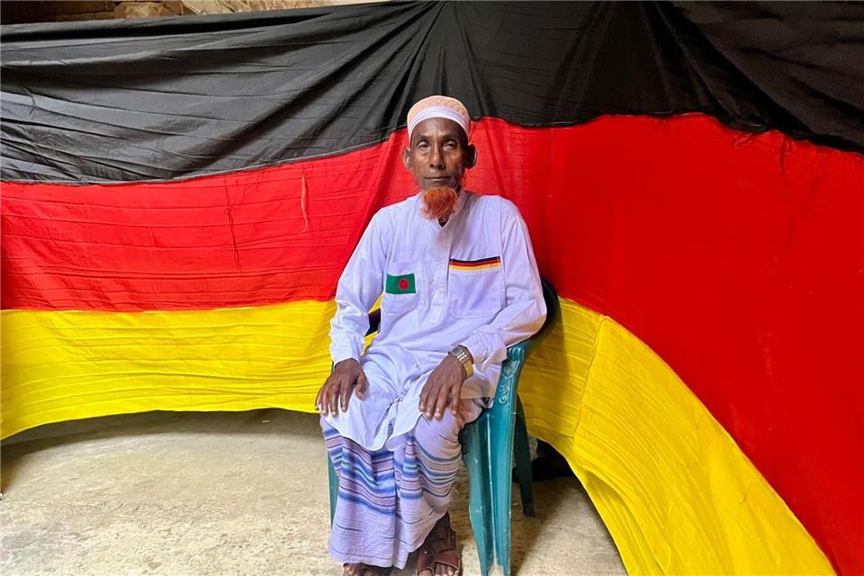 Der 77-jährige bangladeschische Bauer Amjad Hossain posiert mit einer deutschen Fahne, die er zu Hause genäht hat. Nazrul Islam/dpa