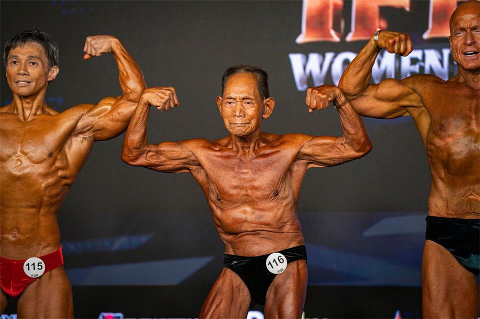Der 90-jährige japanische Bodybuilder Toshisuke Kanazawa (M) nimmt an den IFBB-Weltmeisterschaften im Fitness und Bodybuilding 2026 in Santa Susanna in Spanien teil.Pau Venteo/AP/dpa