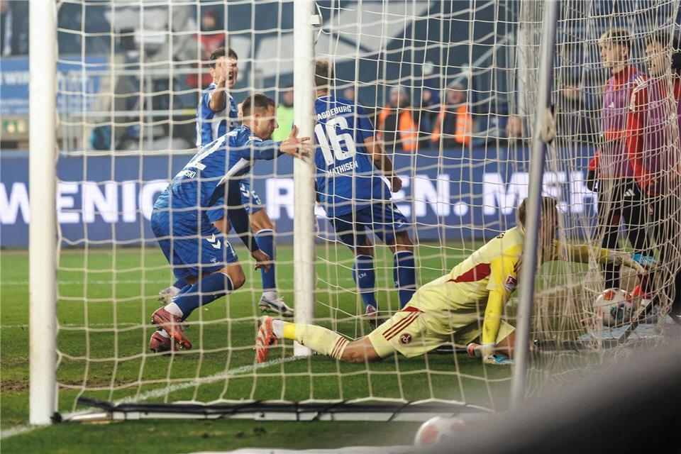 Der Anfang vom Ende: Nürnbergs Torwart Jan Reichert landet beim 0:1 mit dem Ball im Netz. Links Magdeburgs Torschütze Mateusz Zukowski.Andreas Gora/dpa