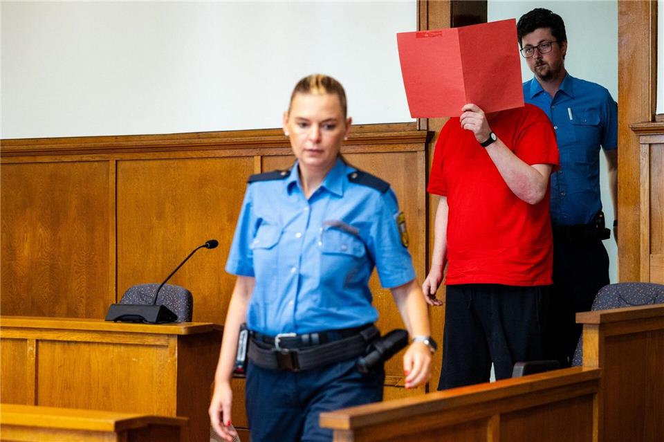 Der Angeklagte (M) wird von Justizvollzugsbeamten zur Urteilsverkündung in den Saal 38 des Landgerichts Saarbrücken geführt.Laszlo Pinter/dpa