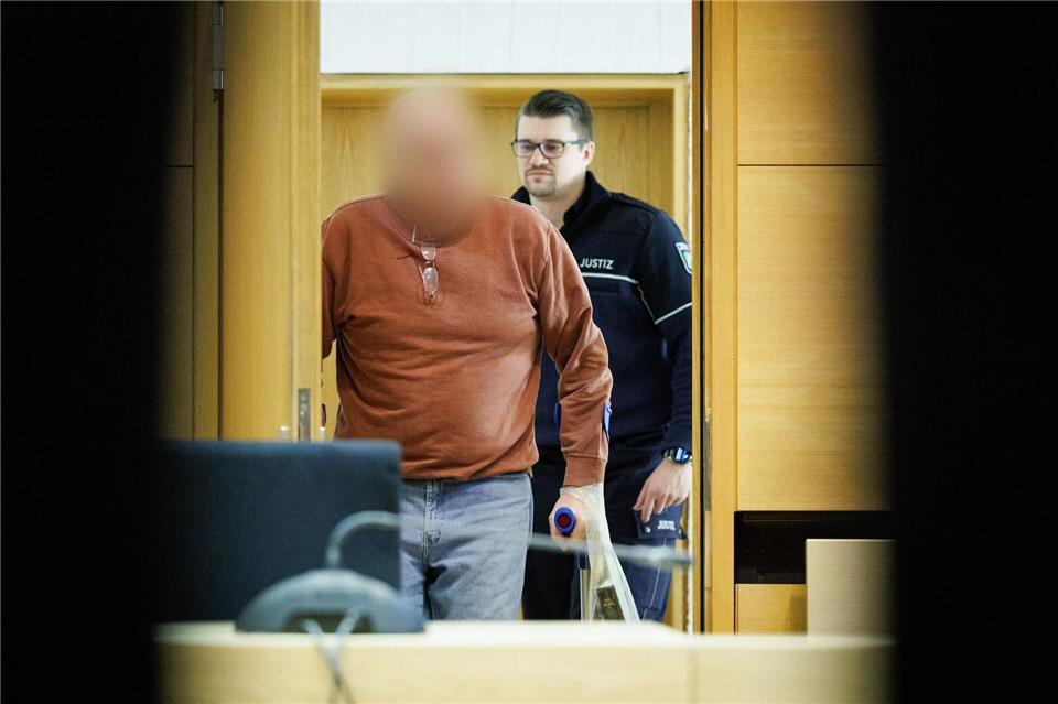 Der Angeklagte kommt in Begleitung eines Justizbeamten in den Prozesssaal am Landgericht Bielefeld. Friso Gentsch/dpa
