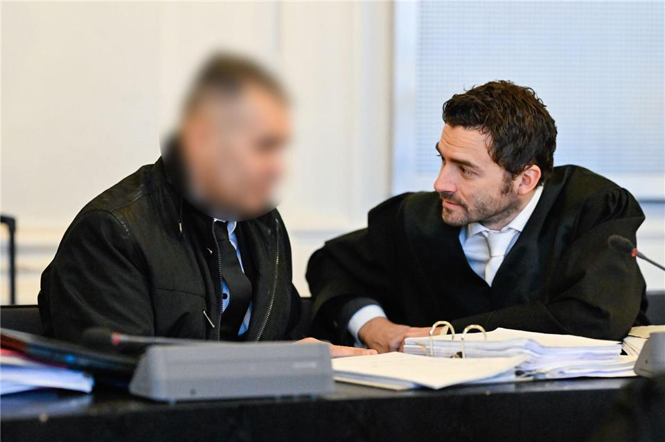 Der Angeklagte spricht im Verhandlungssaal mit seinem Anwalt. Uwe Anspach/dpa