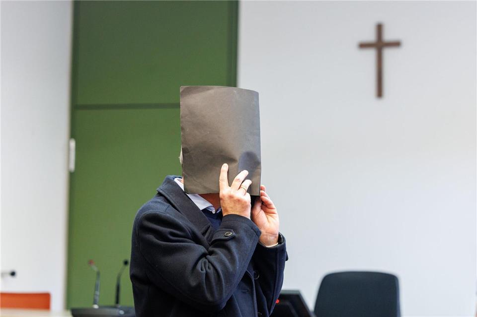 Der Angeklagte versteckte zu Prozessbeginn sein Gesicht. Er bestreitet die Vorwürfe. Matthias Balk/dpa