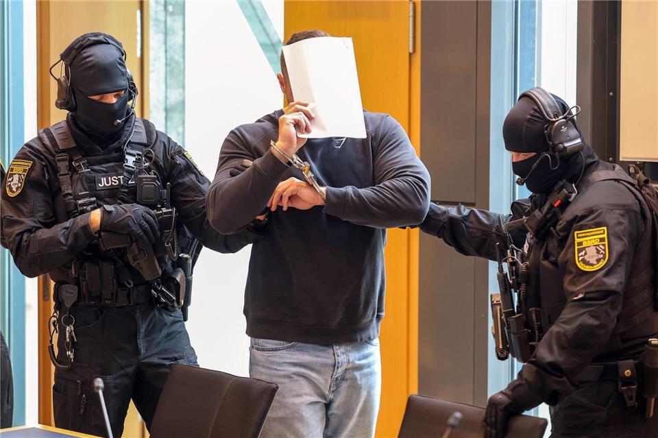 Der Angeklagte wird von zwei Justizbeamten in den Gerichtssaal des Landgerichts Magdeburg gebracht.Peter Gercke/dpa