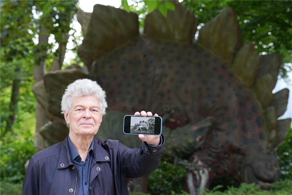 Der Archivar Herman Reichenbach zeigt auf seinem Handy historische Schwarz-Weiß-Fotos der Dino-Skulpturen.Marcus Brandt/dpa