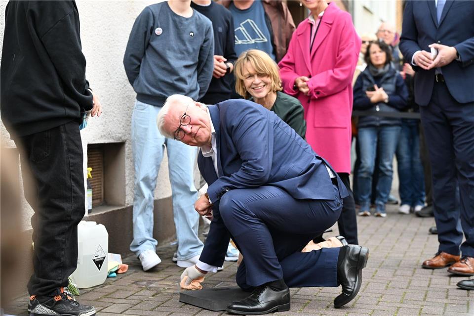 Der Bundespräsident packt persönlich mit an: Er reinigt Stolperstein in Dorsten.Federico Gambarini/dpa
