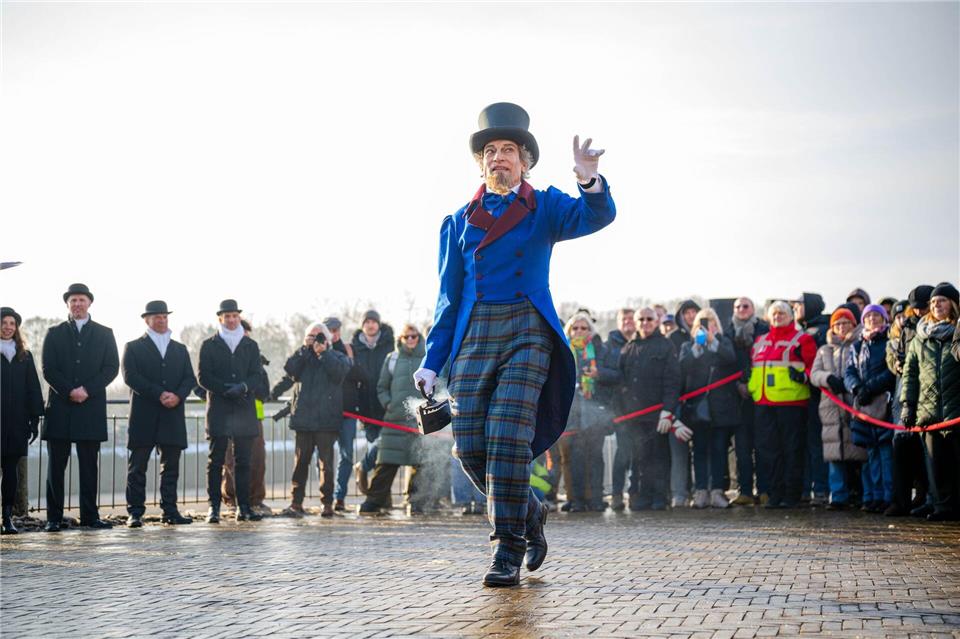 Der Eiswettenschneider gestikuliert am Ufer der Weser.Sina Schuldt/dpa