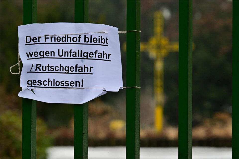 „Der Friedhof bleibt wegen Unfall / Rutschgefahr geschlossen!“ steht an einem Eingang des Friedhofs St. Johannes-Evangelist. Sebastian Christoph Gollnow/dpa