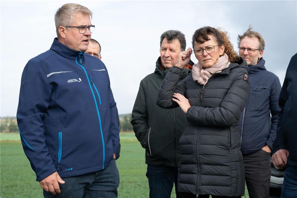 Der Geschäftsführer des Gewässerverbandes Kleine Elster-Pulsnitz, Marcel Ludewig (links), informiert Agrarministerin Hanka Mittelstädt (rechts) an der Schwarzen Elster bei Plessa über den Stand von Hochwasserschutz und Deichpflege. Sebastian Kahnert/dpa
