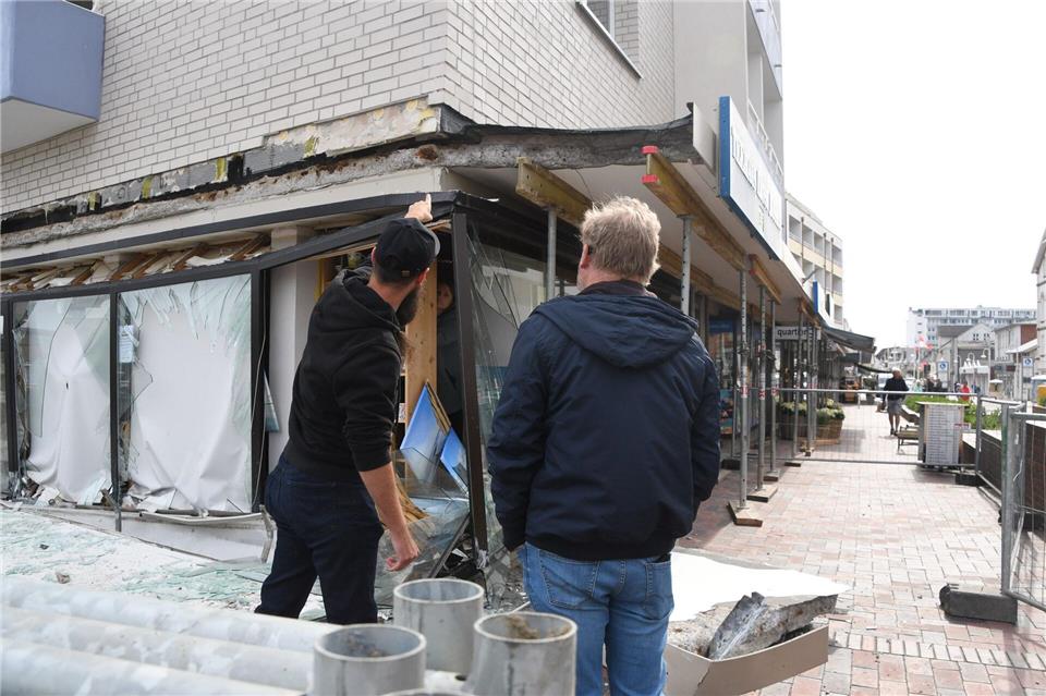 Der Geschäftsführer (l) eines Modeladens in Westerland und ein Mitglied der Hausverwaltung schauten sich die Unglücksstelle gemeinsam anLea Albert/dpa