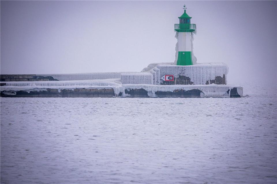Der Leuchtturm auf der Molenspitze am Haffen von Sassnitz ist mit einem Eispanzer überzogen. Jens Büttner/dpa