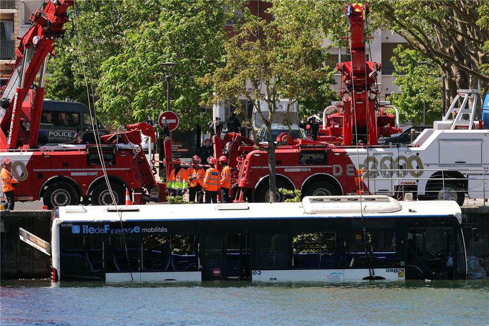 Der Linienbus wird von Kränen aus dem Fluss geborgen.Thomas Samson/AFP/dpa