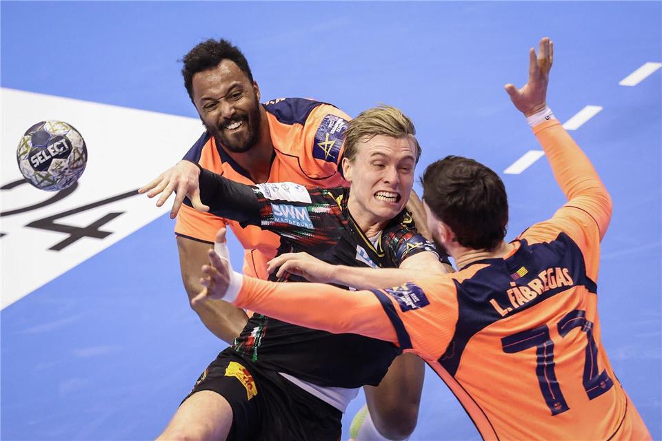 Der Magdeburger Gisli Kristjansson (M) spielt gegen Barcelonas Timothey N’Guessan (l) und Ludovic Fabregas (r) in der Champions League.Ronny Hartmann/dpa-Zentralbild/dpa