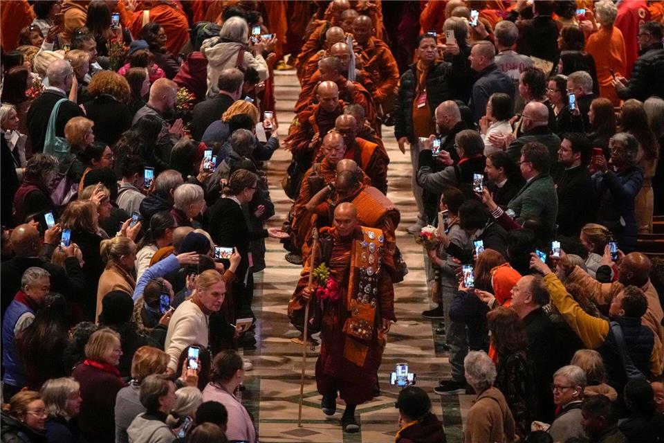 Der Mönch Bhikkhu Pannakara (vorne) und seine buddhistischen Mitbrüder verlassen die Washington National Cathedral nach einer Veranstaltung anlässlich ihres Marsches für den Frieden.Mark Schiefelbein/AP/dpa