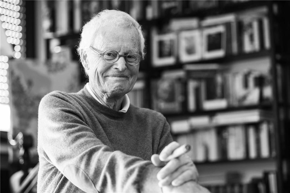 Der Porträtfotograf Konrad Rufus Müller sitzt in seinem Wohnzimmer.