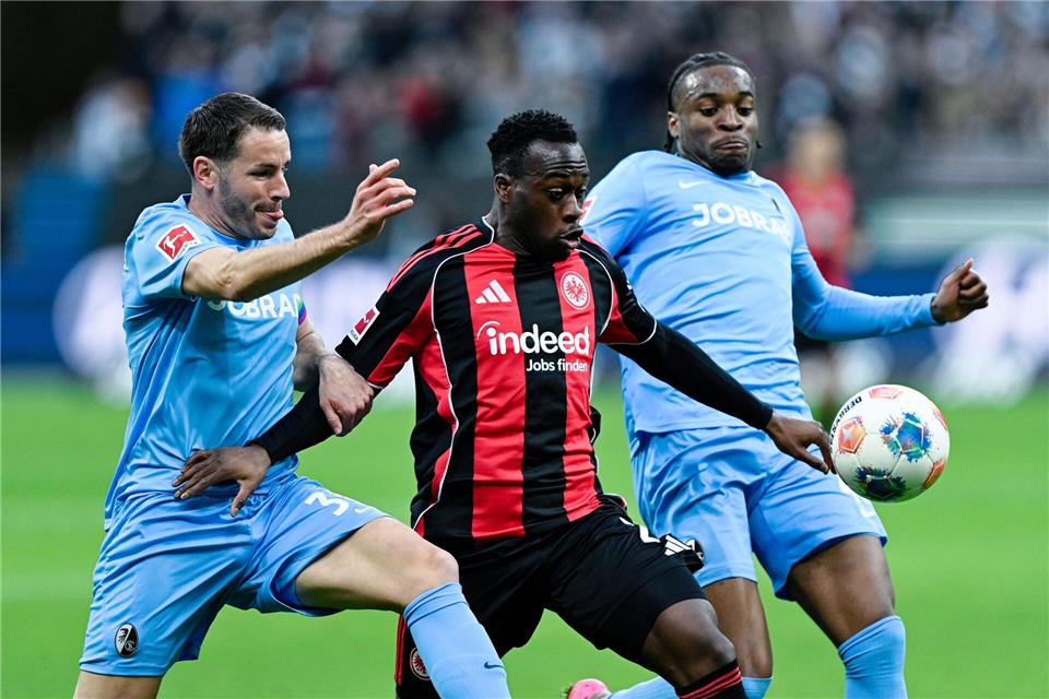 Der SC Freiburg um Christian Günter (l) und Bruno Ogbus (r) sowie Eintracht Frankfurt mit Arnaud Kalimuendo (M) lieferten sich ein umkämpftes Duell.Uwe Anspach/dpa