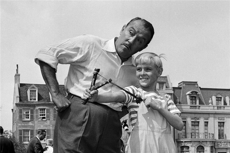Der Schauspieler Jay North ist tot - hier ist er als Dennis am Set in Hollywood mit einer Schleuder und dem Schauspieler Gale Gordon zu sehen. (Archivbild von 1962)David F. Smith/AP/dpa