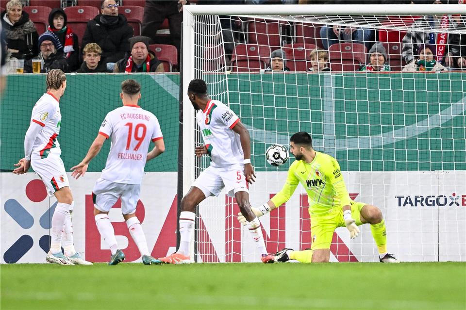 Wagners Horrorwoche: „Verunsichert? Null komma null“  Der Schuss, der zum Augsburger Pokal-K.o. führt. Verteidiger Chrislain Matsima (M) fälscht den Ball auch noch unglücklich und damit unhaltbar ab. Harry Langer/dpa